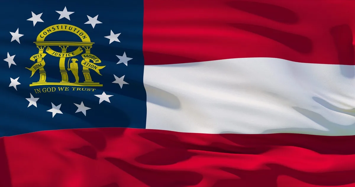 Georgia state flag waving, showing the gold state seal and pillars on a blue field beside red and white stripes